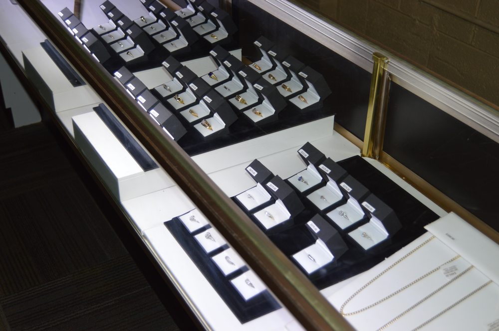 Diamond engagement rings displayed in individual black boxes inside a jewelry case